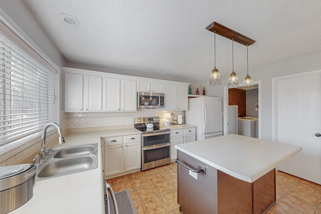 kitchen with a kitchen island, decorative light fixtures, sink, white cabinets, and stainless steel appliances