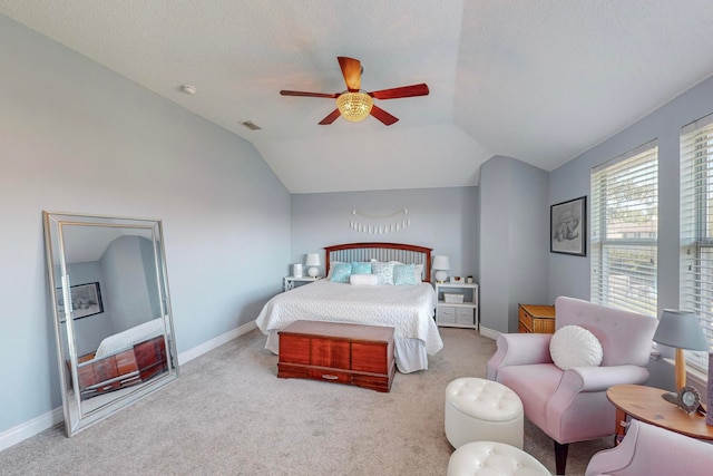 bedroom featuring ceiling fan, light carpet, lofted ceiling, and a textured ceiling