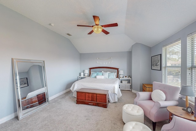 bedroom featuring light carpet, a textured ceiling, vaulted ceiling, and ceiling fan