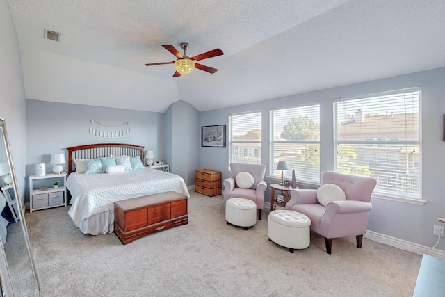 bedroom with ceiling fan, lofted ceiling, light carpet, and a textured ceiling