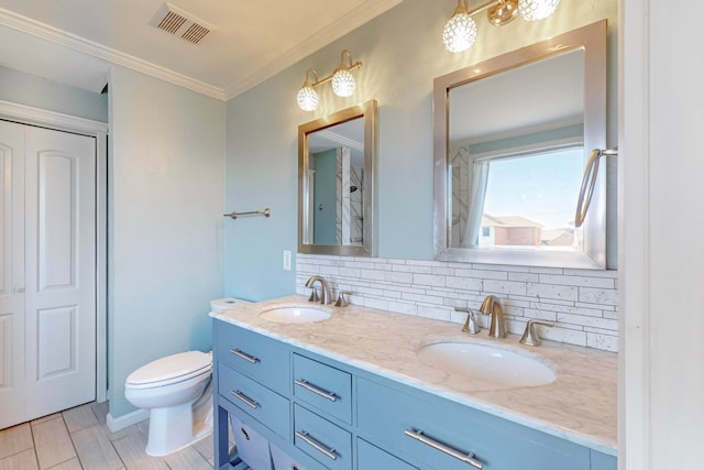 bathroom featuring toilet, vanity, backsplash, and crown molding