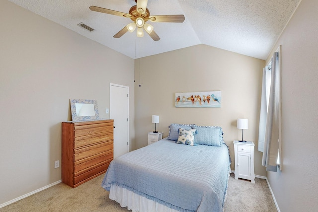 bedroom featuring vaulted ceiling, light carpet, ceiling fan, and a textured ceiling