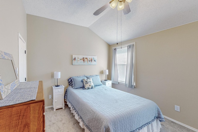 bedroom featuring ceiling fan, lofted ceiling, light carpet, and a textured ceiling