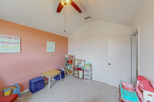 playroom featuring a textured ceiling, carpet, ceiling fan, and vaulted ceiling