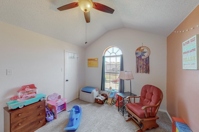 game room featuring ceiling fan, vaulted ceiling, a textured ceiling, and carpet flooring