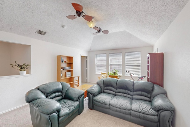 living room with ceiling fan, light carpet, lofted ceiling, and a textured ceiling