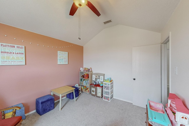 playroom featuring lofted ceiling, a textured ceiling, ceiling fan, and carpet flooring