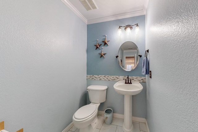 bathroom featuring crown molding, sink, tile patterned floors, and toilet