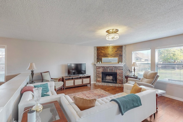 living room with a textured ceiling, a fireplace, and wood-type flooring