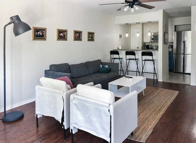 living room featuring ceiling fan, sink, and hardwood / wood-style floors