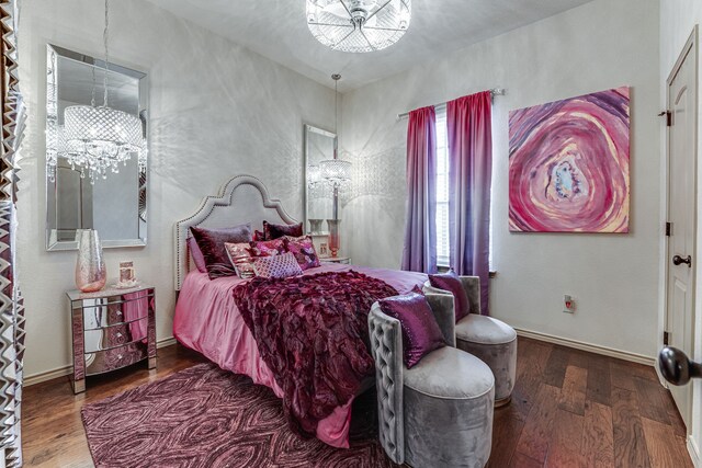 bedroom with baseboards, wood finished floors, and an inviting chandelier