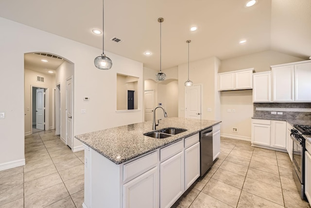 kitchen featuring sink, stainless steel appliances, dark stone countertops, an island with sink, and pendant lighting