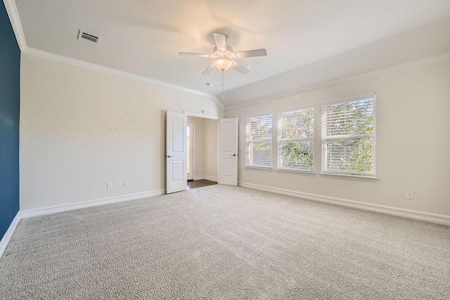 carpeted spare room with ceiling fan and crown molding