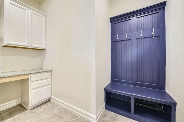 mudroom with light tile patterned floors and built in desk