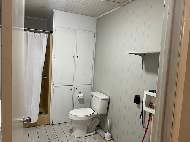 bathroom with wood walls, toilet, and a shower with shower curtain