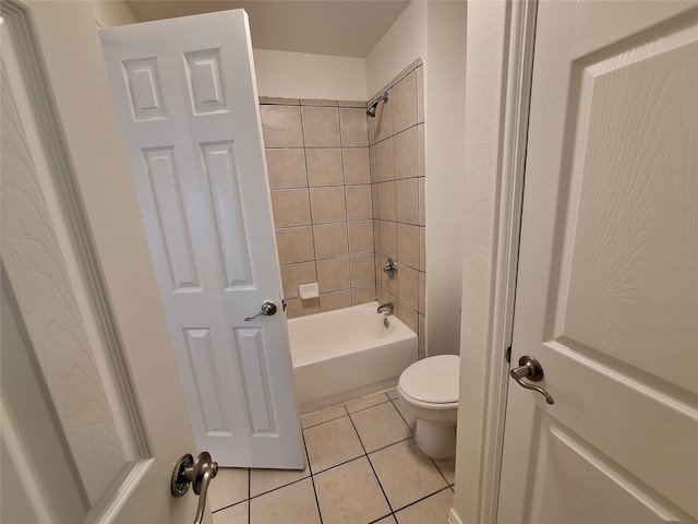 bathroom with tiled shower / bath, tile patterned flooring, and toilet