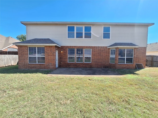 rear view of house featuring a yard