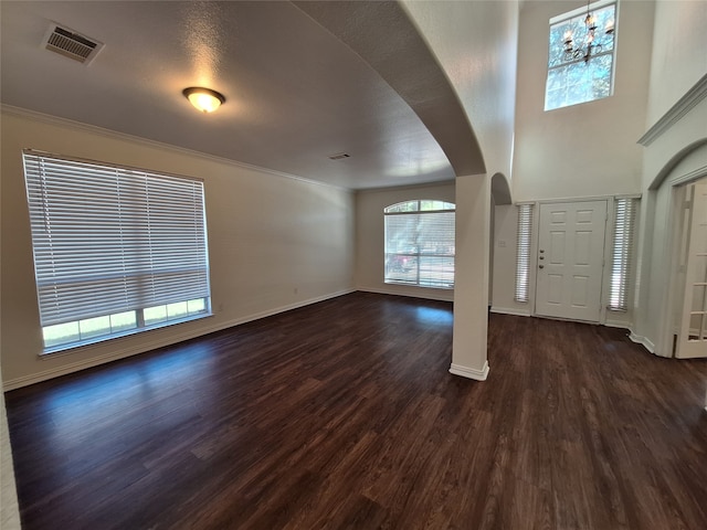 foyer featuring a textured ceiling, ornamental molding, dark hardwood / wood-style flooring, and a chandelier