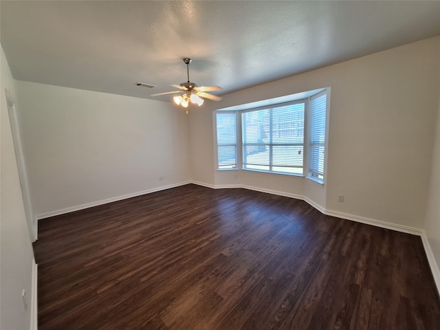 empty room featuring ceiling fan and dark wood-type flooring