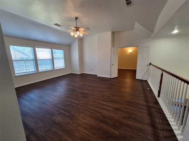 empty room with ceiling fan, lofted ceiling, and dark hardwood / wood-style flooring