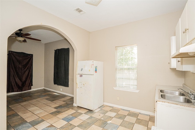 423 W Pembroke Ave, Dallas, TX 75208 - kitchen featuring freestanding refrigerator, a sink, white cabinets, a ceiling fan, and light countertops