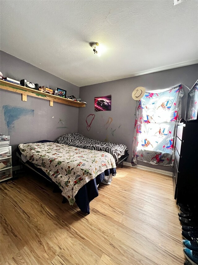 bedroom with a textured ceiling and hardwood / wood-style floors