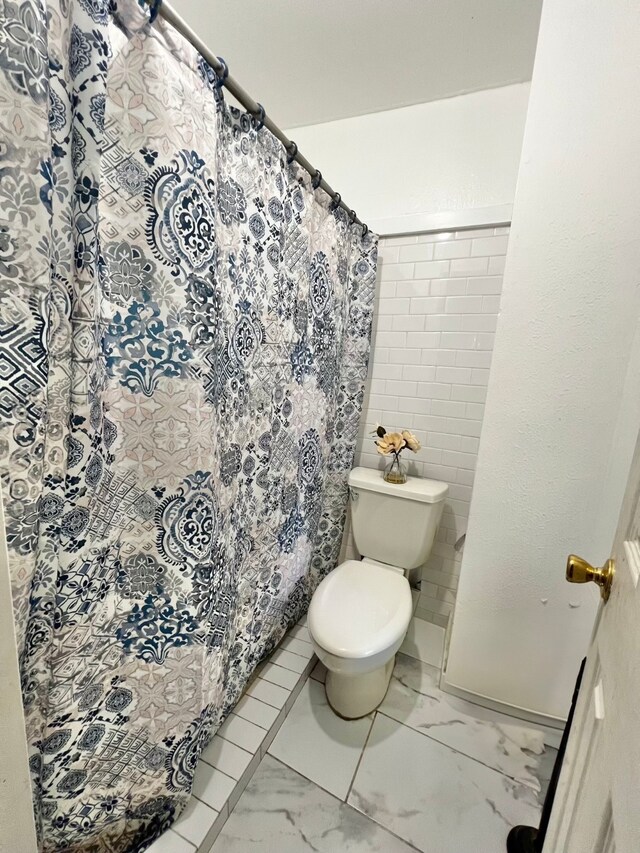 bathroom with a shower with curtain and toilet