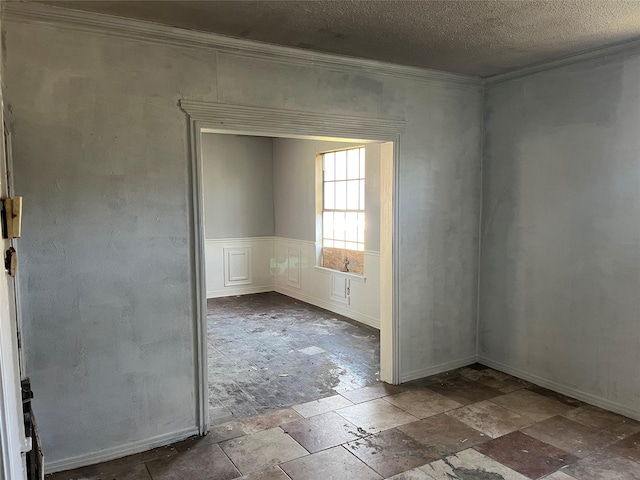 empty room featuring crown molding and a textured ceiling