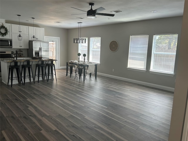 dining space with ceiling fan and dark hardwood / wood-style floors