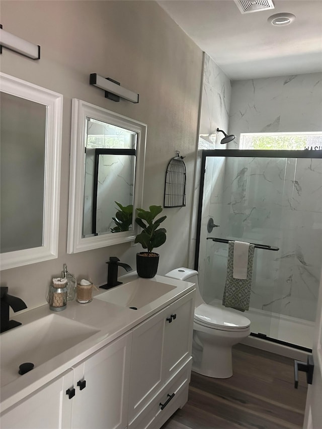 bathroom with wood-type flooring, vanity, toilet, and an enclosed shower