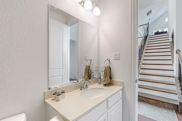 bathroom featuring vanity and lofted ceiling