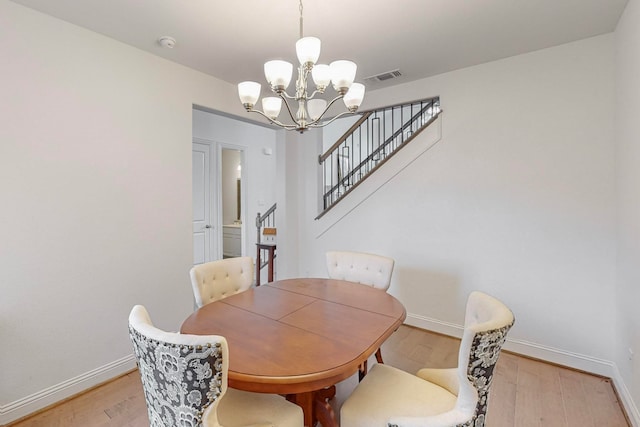 dining area featuring light hardwood / wood-style floors and an inviting chandelier