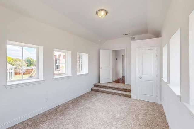 unfurnished room with carpet flooring and lofted ceiling