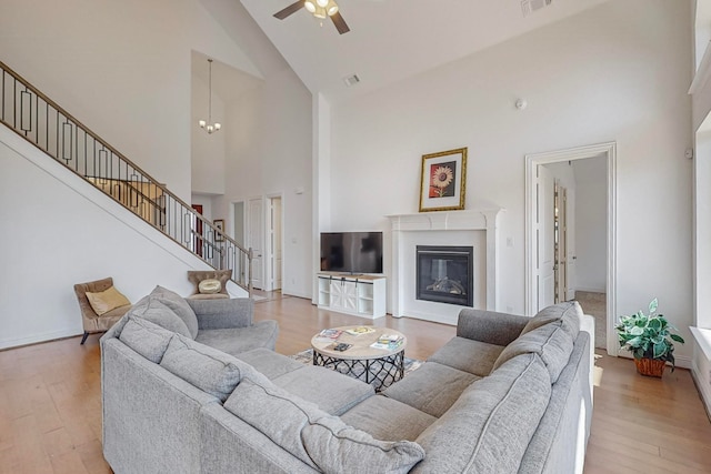 living room featuring light wood-type flooring, high vaulted ceiling, and ceiling fan