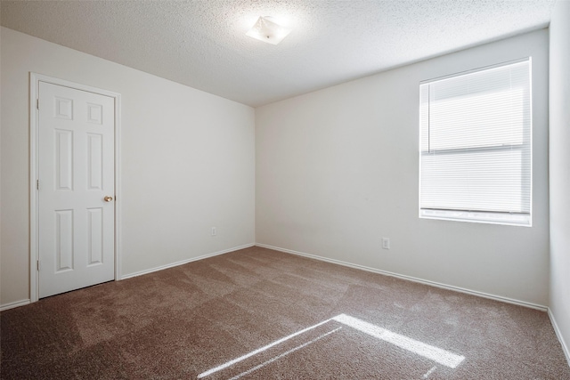 carpeted spare room featuring a textured ceiling