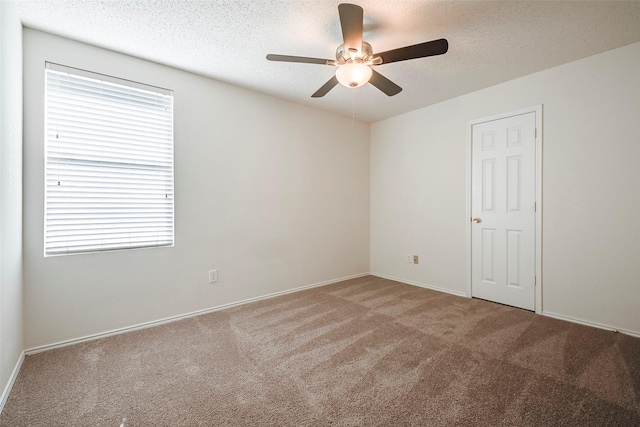 carpeted empty room with ceiling fan and a textured ceiling