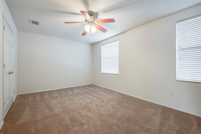 unfurnished room featuring ceiling fan, a healthy amount of sunlight, and light colored carpet