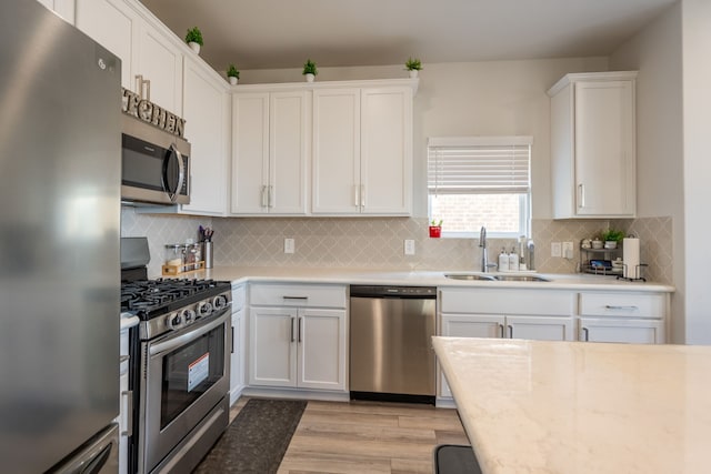 kitchen featuring light hardwood / wood-style floors, sink, stainless steel appliances, and white cabinets