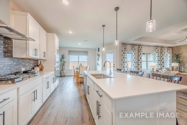 kitchen featuring appliances with stainless steel finishes, plenty of natural light, sink, and a kitchen island with sink