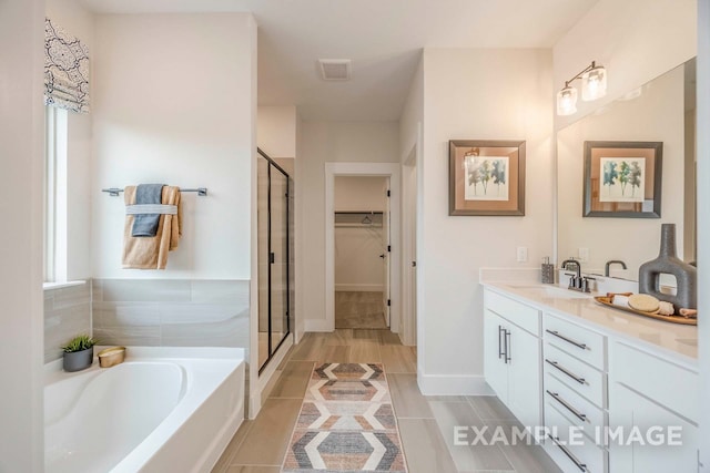 bathroom featuring shower with separate bathtub, vanity, and tile patterned floors