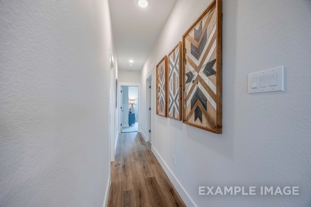 hallway with hardwood / wood-style flooring