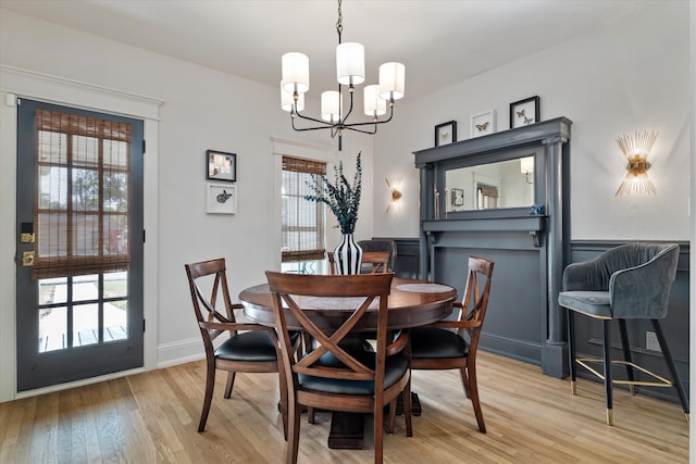 dining area featuring a notable chandelier, light wood-type flooring, and plenty of natural light