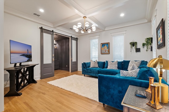 living room featuring ornamental molding, beam ceiling, wood-type flooring, a chandelier, and a barn door