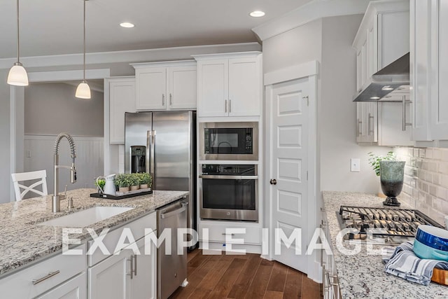 kitchen featuring wall chimney range hood, white cabinetry, stainless steel appliances, and a sink