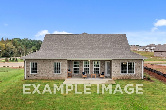 rear view of property with brick siding, roof with shingles, and a yard