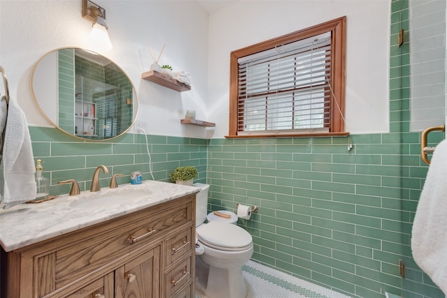 bathroom featuring toilet, vanity, and tile walls