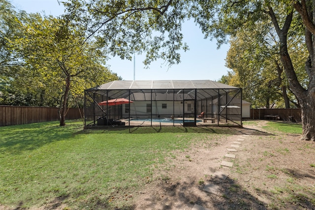 exterior space with a lanai, a lawn, and a fenced in pool