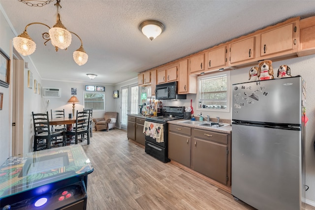 kitchen with black appliances, decorative light fixtures, sink, light hardwood / wood-style flooring, and crown molding