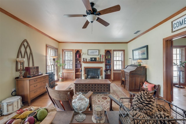 living room with ceiling fan, crown molding, and light hardwood / wood-style flooring