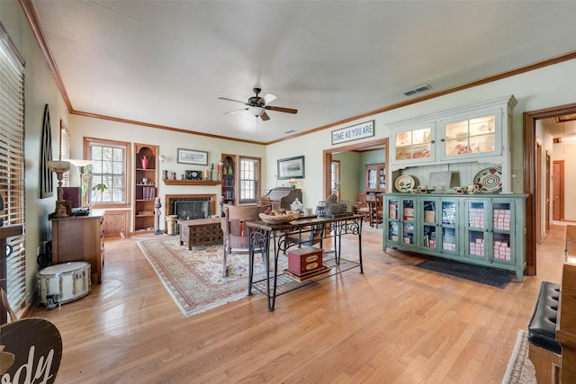 living room with light wood-type flooring, ceiling fan, and ornamental molding